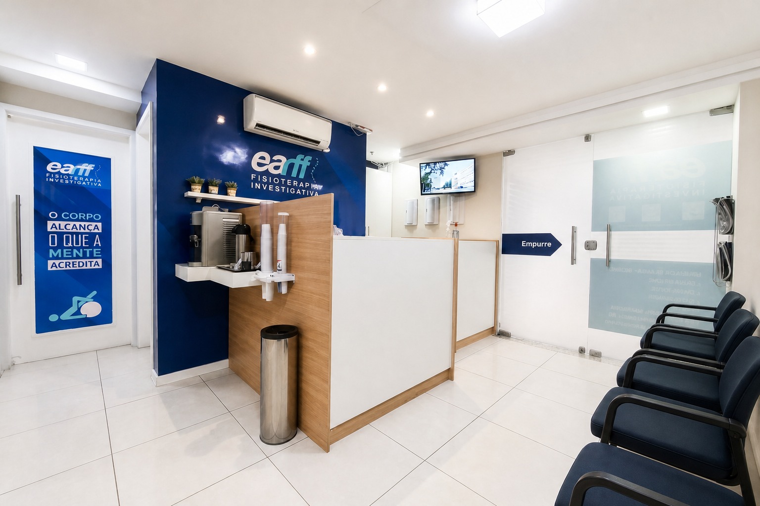 Recepção da unidade EARFF Niterói, balcão em madeira clara com parede azul-petróleo com logo EARFF, cadeiras de espera azul-marinho, ambiente clean e organizado, luz artificial suave, fotografia arquitetônica realista